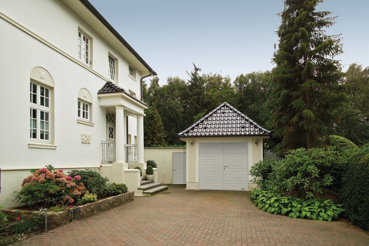Weißes Haus mit Ziegeldach und angrenzender Garage