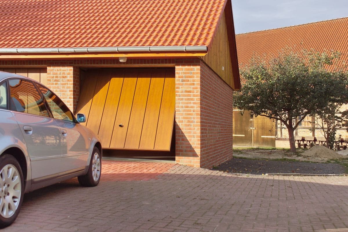 Gemauerte Garage mit teilweise geöffnetem Tor und Ziegeldach
